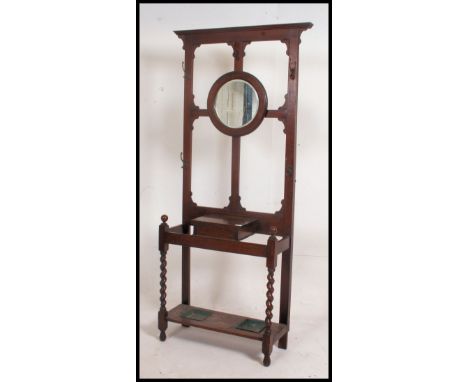 Early 20th century oak hall stand, central circular bevelled mirror above a single glove drawer flanked by two stick stands, 