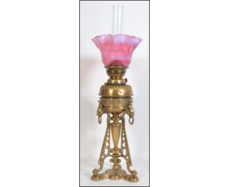 A stunning early 20th century brass oil lamp in the Art Nouveau manner being raised on a tripod base united by lower tier wit