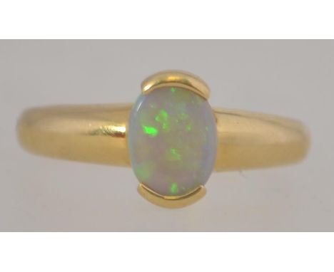 An 18ct gold and opal ladies ring. The buckle style setting with oval opal stone to centre. Shank impressed marked 750. Total