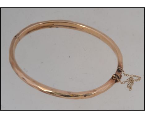 A 9ct gold hallmarked ladies bangle  ( see illustrations ) bearing Birmingham hallmarked date letter W. With safety chain. To