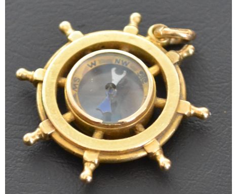 Gold ships wheel / helm , stamped 18ct to bail and tested as such ,  including main body . Delightful maritime item encasing 