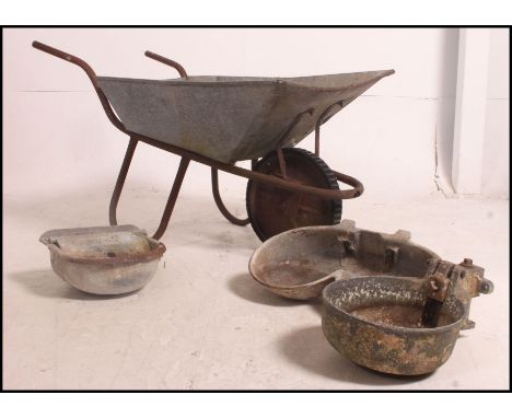 A mid 20th century galvanised wheel barrow along with three vintage cast water troughs please see images