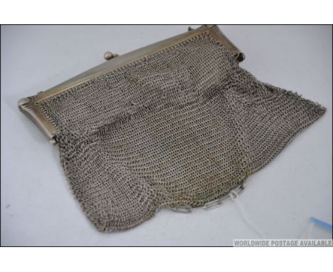 A large silver white metal ladies mesh purse with finial clasp and chain handle, circa early 20th century. Measures: 16cms wi