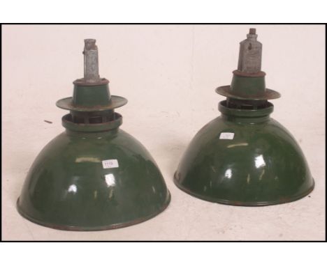 A pair of large vintage industrial factory enamel ceiling lights, retaining the original fixture points with detachable green