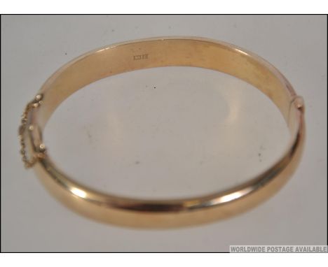 A hallmarked 9ct gold bangle bracelet. Hallmarked for Birmingham , maker L and Co. Weight 17.7g.