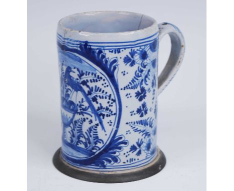 An English blue and white delftware tankard, 18th century, decorated with birds perched upon an urn above a pewter footrim, h