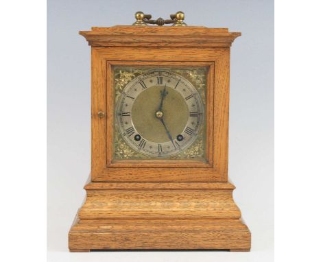 An Edwardian oak three-glass mantel clock, the 5" square brass signed by the retailer Fraser of Ipswich, having a silvered Ro