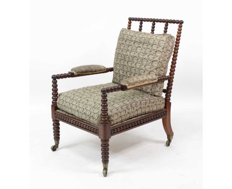 A Victorian rosewood bobbin turned armchair, having squab cushions and stuffover arms, further bobbin decorated frieze and on