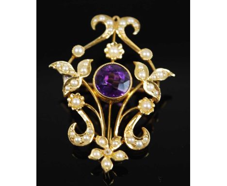 An Edwardian yellow metal amethyst and seed pearl openwork pendant brooch, comprising a central round faceted amethyst within