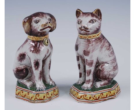 A pair of Royal Tichelaar Makkum Delft polychrome models of animals, circa 1900, each shown in seated pose, the cat facing le