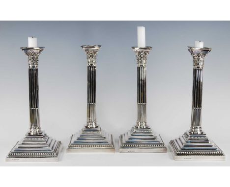 A set of four Queen Elizabeth II silver candlesticks, the stop-fluted Corinthian columns with embossed capitals and detachabl