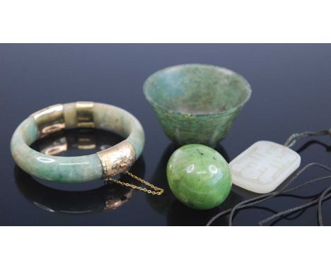 A Chinese celadon jade hinge bangle having engraved yellow metal mounts and clasp, one stamped 14ct, and with further yellow 