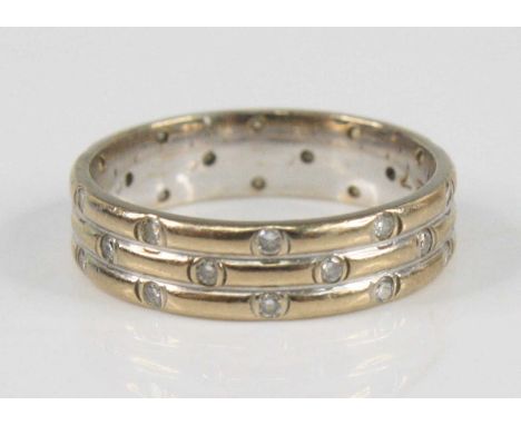 An 18ct white gold diamond set three-row wedding band, having 29 round brilliant cut diamonds (one deficient) in scatter sett