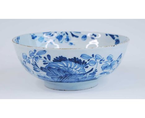 An English blue and white delftware bowl, probably Liverpool, circa 1750, decorated with flowers, dia.19cm Reference: Archer 