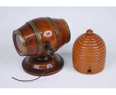 A 19th century treen cotton dispenser in the form of a brass coopered walnut barrel, the right end unscrewing to reveal a tur