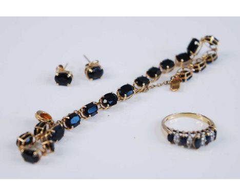 A yellow metal sapphire suite, comprising a sapphire line bracelet featuring 18 oval faceted sapphires in claw settings, with