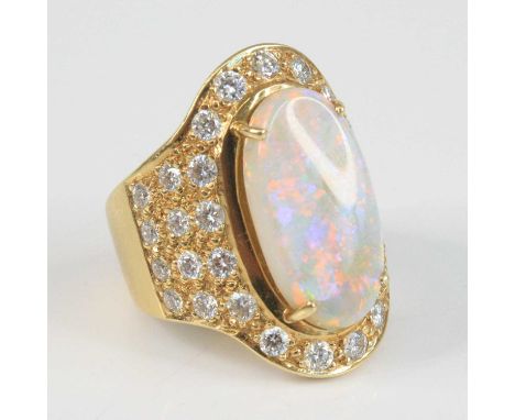 A modern yellow metal opal and diamond oval cluster ring, of good size, the four-claw set cabochon opal with white overtone a