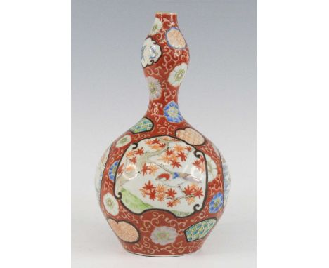 A Japanese Imari porcelain vase, Meiji period, the garlic neck above a gobular body, enamel decorated with alternating panels