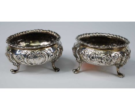 A pair of Victorian silver salts, of squat circular form, repousse floral embossed and with gadrooned everted rims, each stan