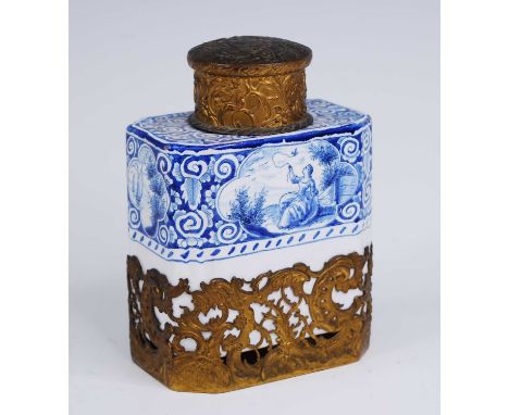 A Delft blue and white tea caddy, 19th century, decorated with a reclining lady, having Rococo style gilt metal lid and sleev
