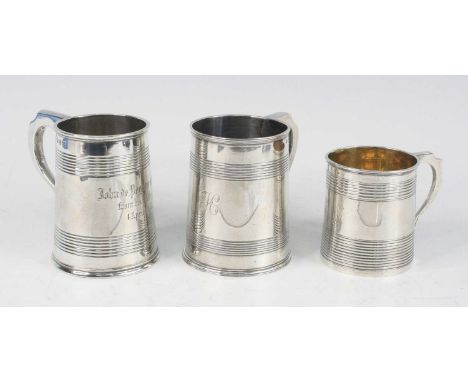 Three silver christening tankards, being a George III example, of cylindrical form with reeded decoration and shaped scroll h