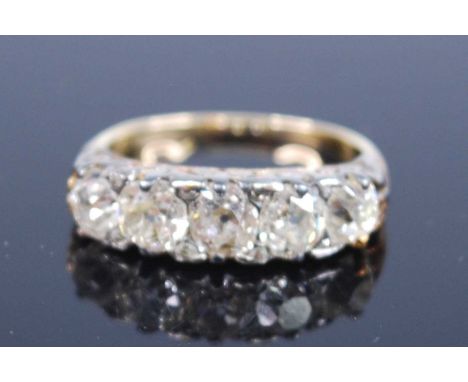 A late Victorian yellow and white metal diamond five-stone half eternity ring, featuring five graduated old cushion cut diamo