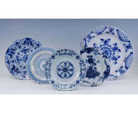 A Delft blue and white charger, 18th century, decorated with geometric motifs, dia.34cm, together with four blue and white de