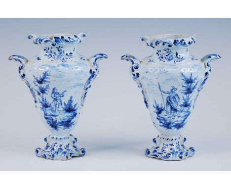 A pair of Delft blue and white vases, late 17th/18th century, each of wrythen form, flanked by C-scroll handles, decorated wi