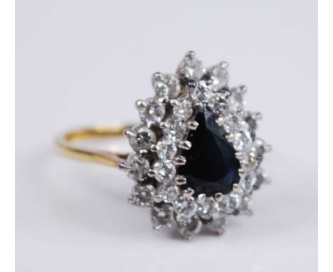 An 18ct yellow and white gold, sapphire and diamond pear shaped cluster ring, featuring a centre pear cut sapphire within two