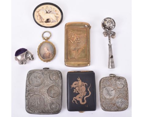 A silver spin cushion in elephant form, with two sovereign cases, a rattle, a Get It At Harrods japanned match case a carved 