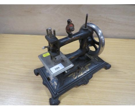 A VINTAGE MINATURE SEWING MACHINE WITH SPARES 
