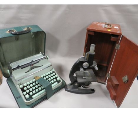 A VINTAGE WOODEN CASED MICROSCOPE WITH A PORTABLE TYPEWRITTER 