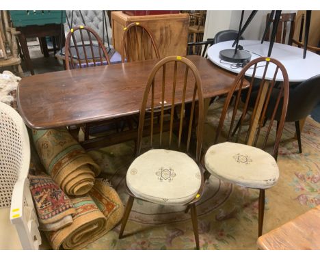A dark Ercol style refectory dining table with four hoop back chairs