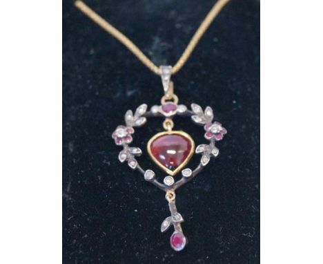 A heart shaped cabochon ruby surrounded by a ruby and diamond floral wreath pendant, set in unmarked yellow and white metal; 
