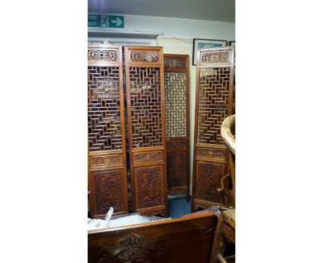 A Chinese carved and pierced hardwood four-fold screen, each panel 210 x 42cm.