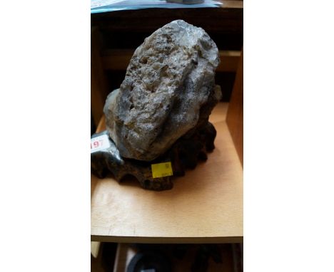 An agate boulder pebble, of natural form, on a shaped and fitted hardwood stand, total height 18cm.