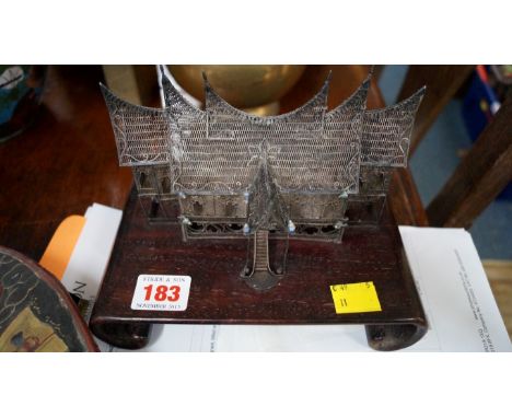 A Chinese filigree white metal temple, with applied shell decoration, 17cm wide, on hardwood scroll stand.