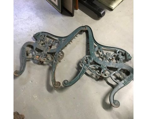 A Pair of cast iron bench ends detailed with lion head arm rests. 