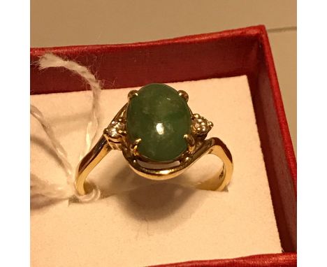 An 18ct gold ring set with a large single oval cut jade set with a single diamond to each shoulder. Ring size S and weighs 5.