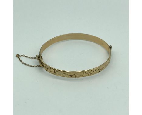 A 9ct gold metal core ornate bangle. Weighs 12.5grams