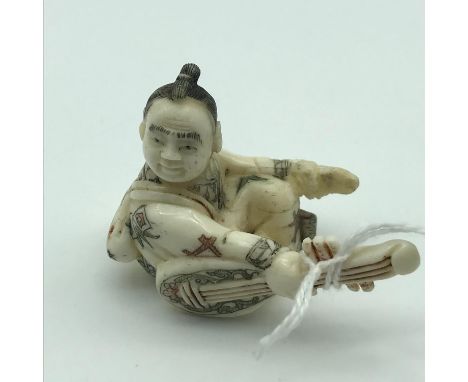 A Meiji period Japanese hand carved bone netsuke of a musician. Showing nice details to the kimono gown and instrument. Signe