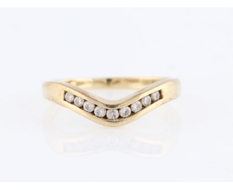 A 9ct yellow gold diamond wishbone ring, channel set with nine graduated round brilliant cut diamonds, hallmarked Sheffield, 