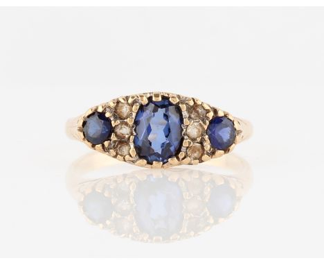 A hallmarked 9ct yellow gold sapphire ring, set with three graduated oval cut sapphires (possibly synthetic) with colourless 