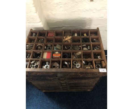 A stained wood seven drawer storage chest containing tools etc.