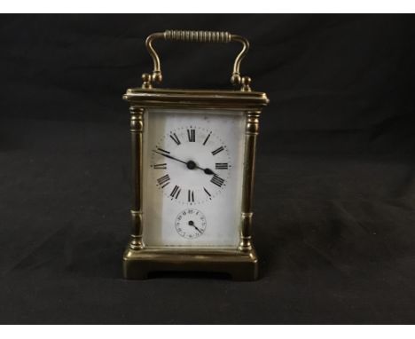A French, brass carriage clock with enamelled front and Roman numerals to face.