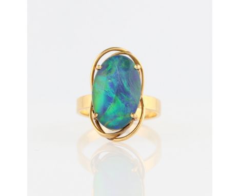 A black opal triplet ring, set with an oval black opal triplet, with an open metalwork surround, stamped 750, ring size L.