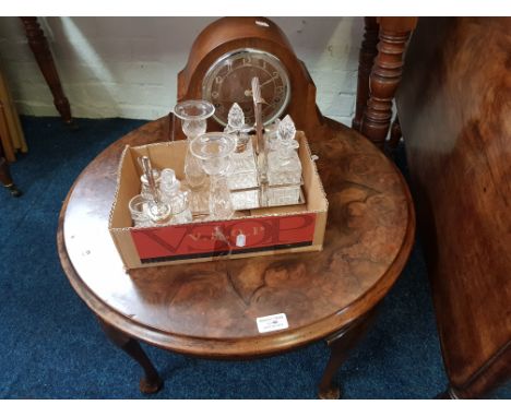 A circular veneered coffee table, oak cased mantle clock, a pair of glass candlesticks and two crilet sets on plated bases.