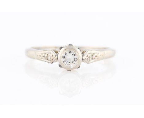 A diamond ring, set with a central round brilliant cut diamond, measuring approx. 0.25ct, flanked to either side with eight-c