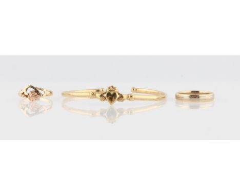 A Claddagh bangle, stamped 9k, together with a hallmarked 9ct wedding band and a hallmarked 9ct open metalwork leaf design ri