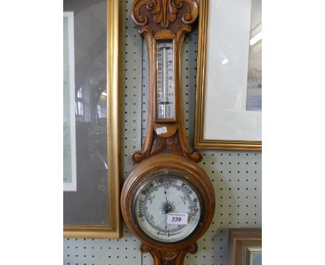 An early 20th Century oak carved aneroid barometer.